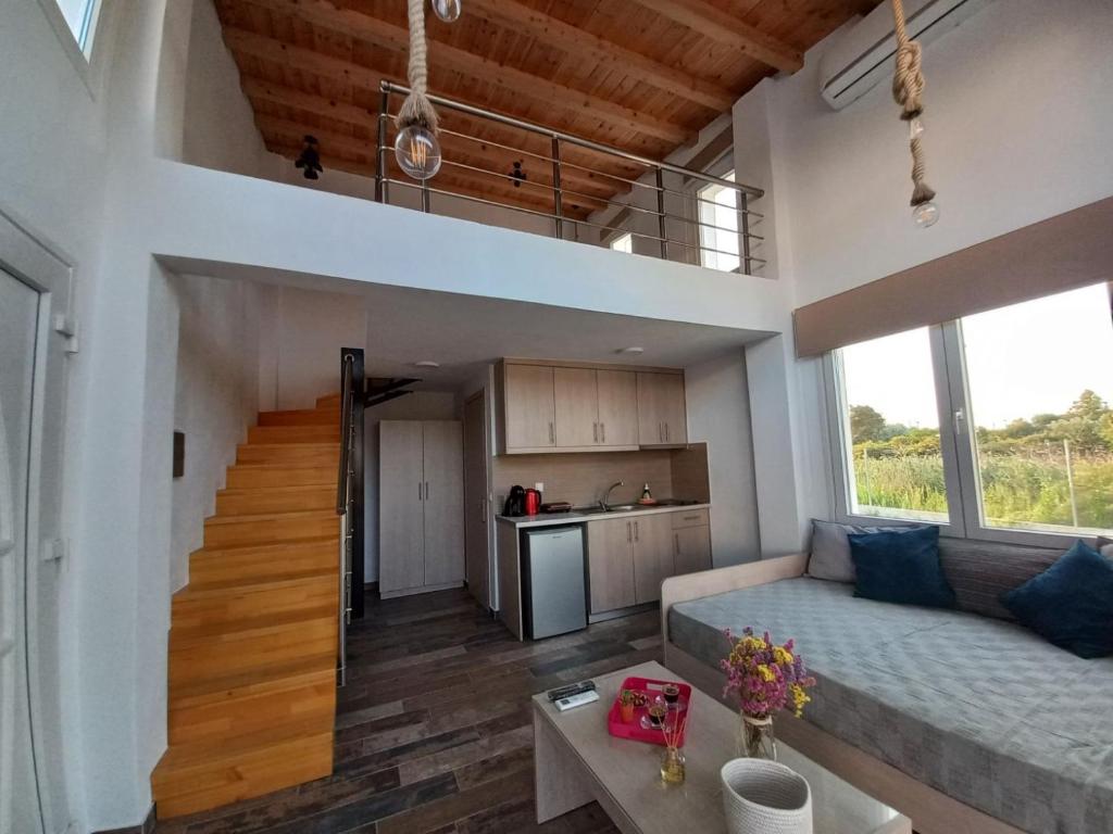 een grote woonkamer met een bank en een tafel bij KTIMA MORAITI - Seaside Houses in Kateríni