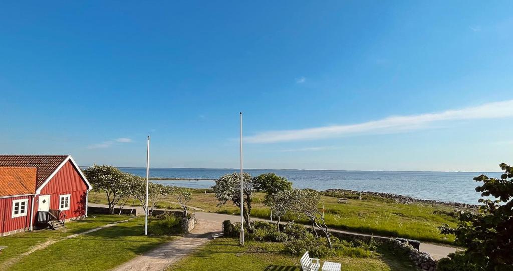 uma casa vermelha numa colina junto ao oceano em Magnarp Strandbad em Vejbystrand