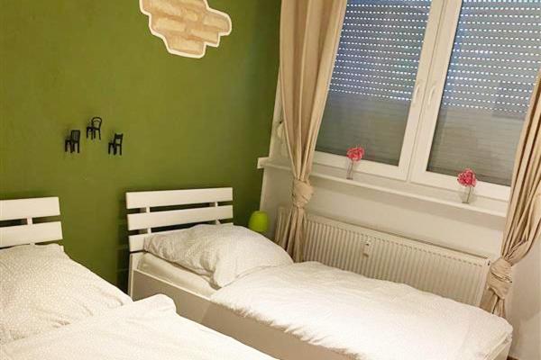 Dormitorio verde con 2 camas y ventana en Workers Apartment Bergisch Gladbach Bensberg, en Bergisch Gladbach