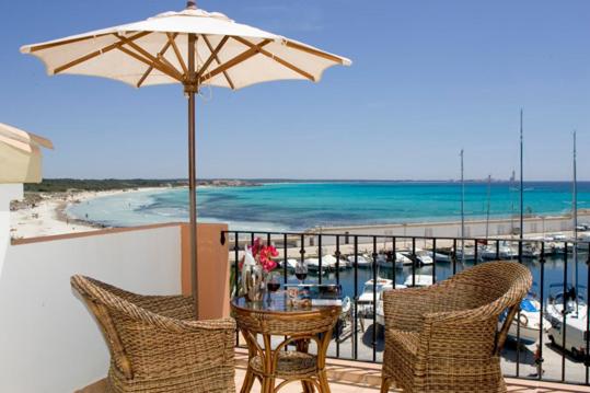 - un balcon avec une table, des chaises et un parasol dans l'établissement Balcón d'es Trenc, à Sa Ràpita