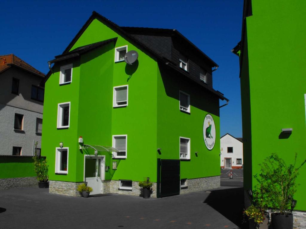 un bâtiment vert avec un toit noir dans l'établissement Pension Froschprinz, à Seligenstadt