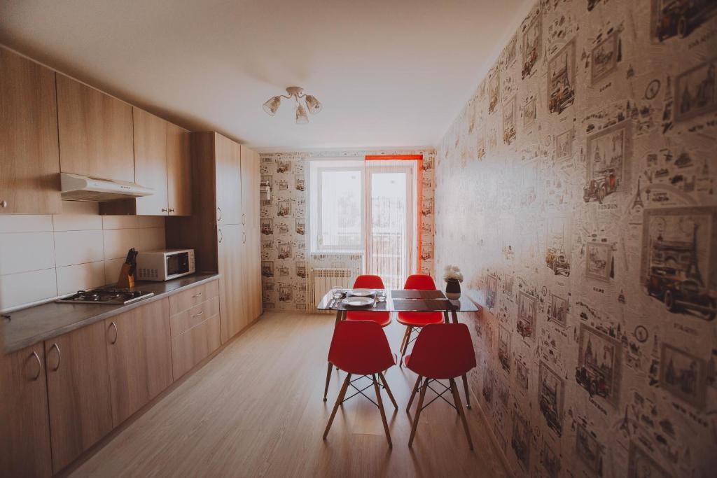 eine Küche mit einem Tisch und 4 roten Stühlen in der Unterkunft Standard Plus Apartment in Poltawa