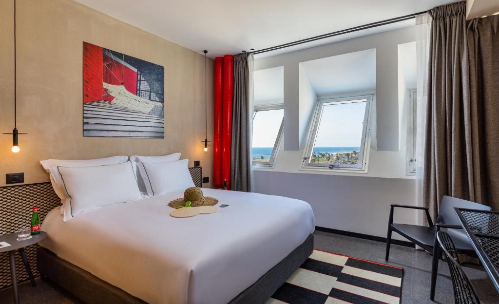 um quarto de hotel com uma cama grande e uma janela em Brown Brut Seafront Hotel, a member of Brown Hotels em Tel Aviv