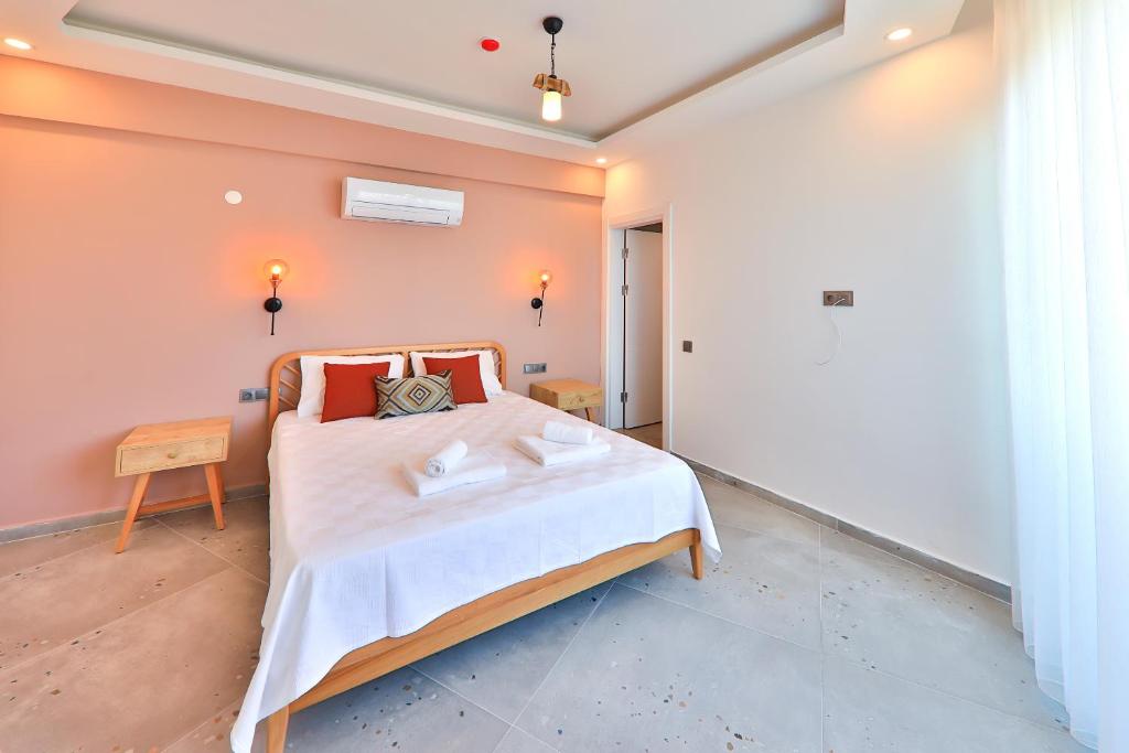 a bedroom with a bed with white sheets and red pillows at Happy Kaş Apart in Kaş