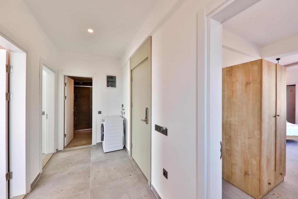 a hallway with white walls and a wooden door at Happy Kaş Apart in Kaş