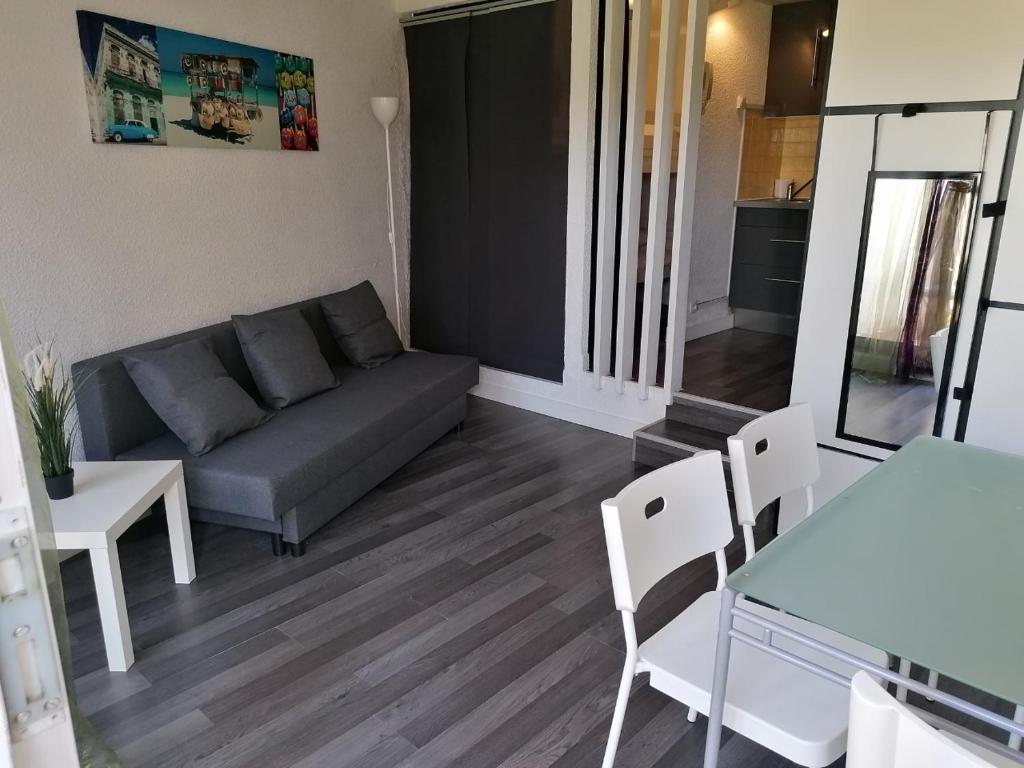 un salon avec un canapé et une table dans l'établissement Charmant studio Residence Carnon plage-Climatisation-Parking Prive, à Carnon-Plage