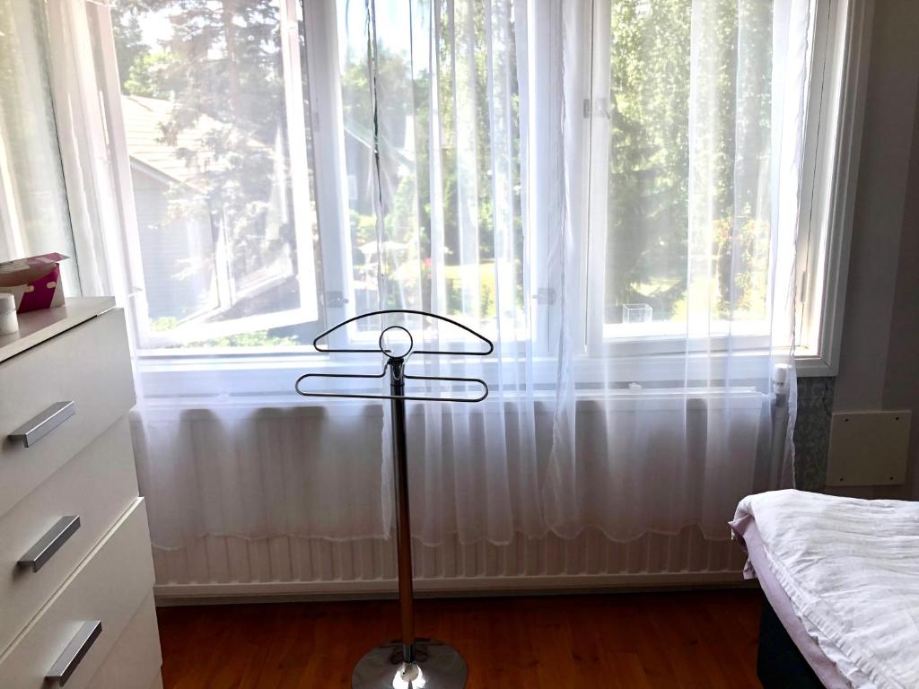 um candeeiro de chão em frente a uma grande janela em Villa Alex em Helsinque