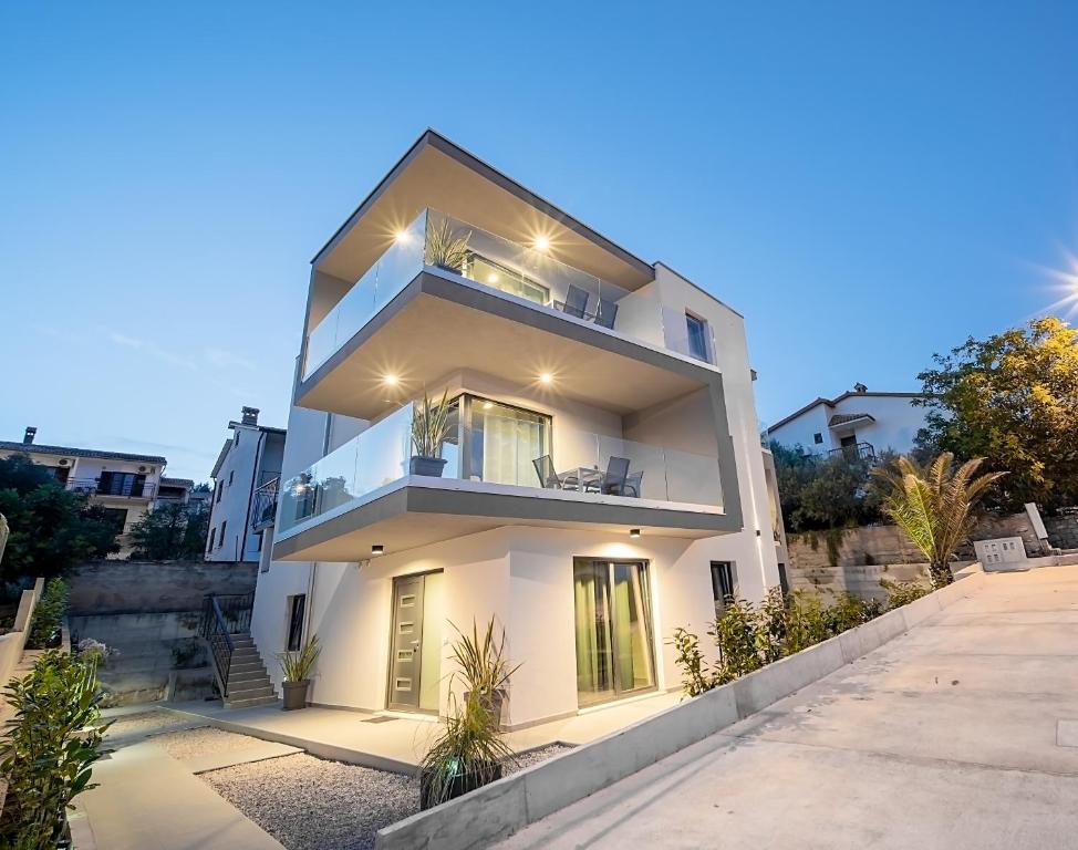 a white apartment building with a balcony at Villa Apartments Lela in Rabac