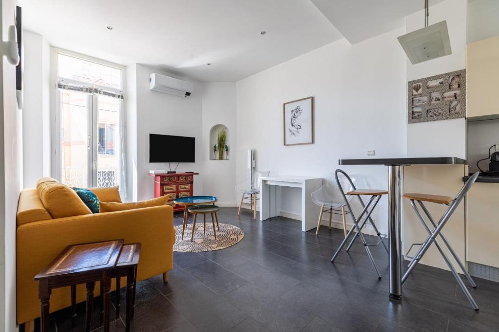 un salon avec un canapé jaune et une table dans l'établissement Charming Apartment In The Center Of Cannes, à Cannes