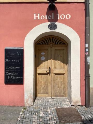 a building with a wooden door in front of it at Hotel 100 in Pardubice