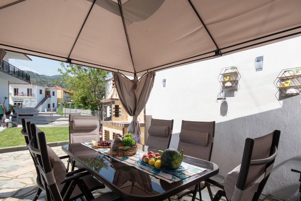 a table and chairs with an umbrella on a patio at Stavroula's Paradise House in Sikia