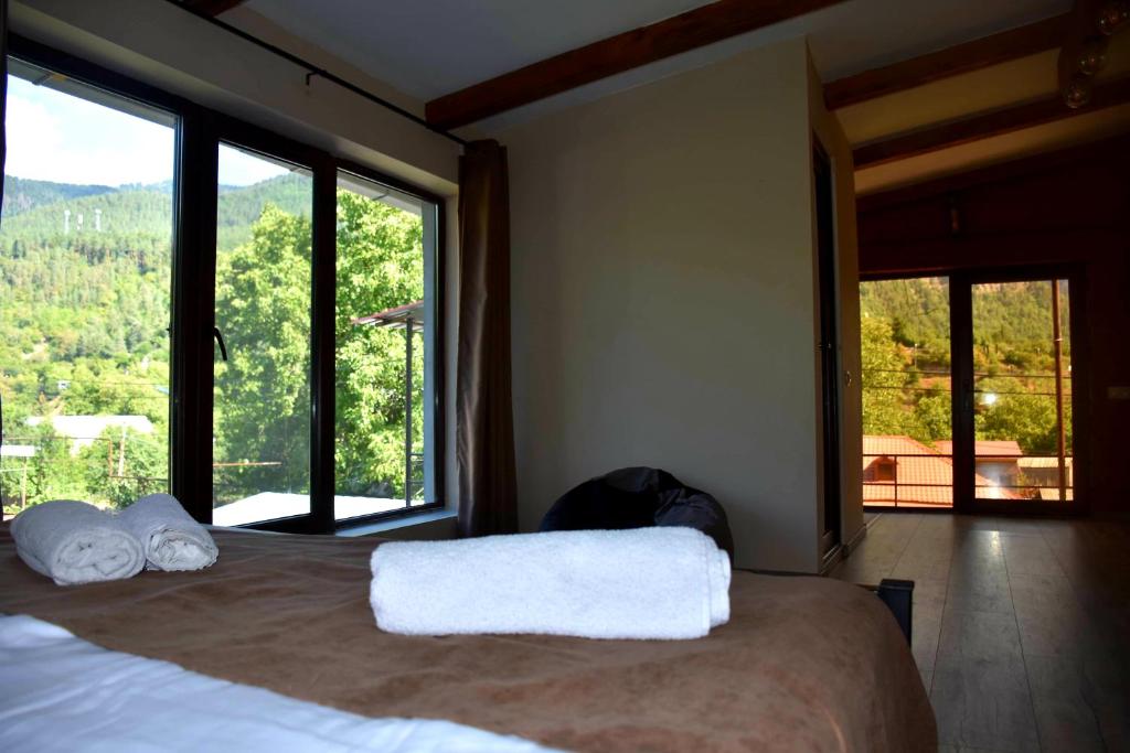 a bedroom with a bed with a large window at holiday home in Borjomi
