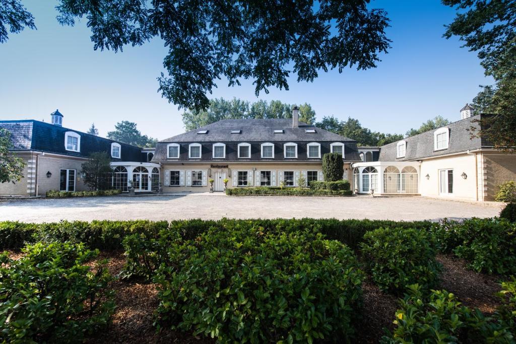 an exterior view of a large house with a driveway at Hotel In den Bonten Os in Rijmenam