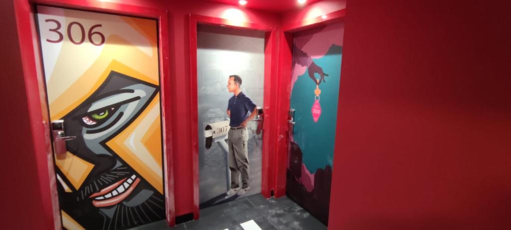 a man standing in a locker room with a painting at Dormirdcine Alicante in Alicante