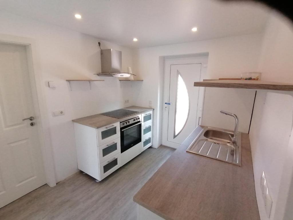 a small kitchen with a stove and a sink at Sharky Ferienwohnung in Bahnhofsnähe in Niebüll