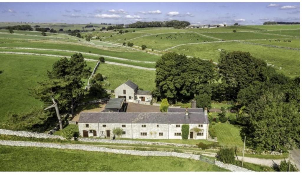 an aerial view of a white house in a field at Denver Cottage in Monyash