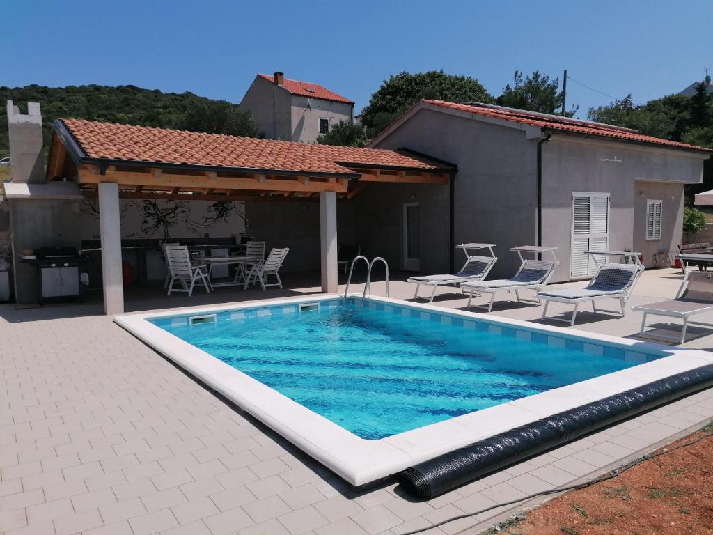 a swimming pool in front of a house at House with pool in Mali Lošinj