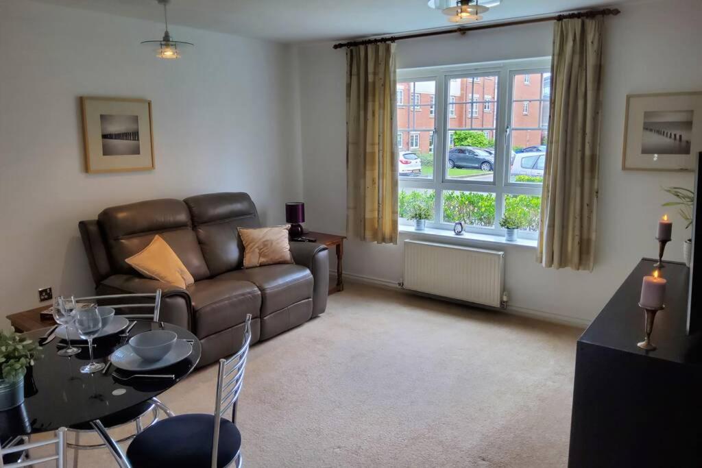 a living room with a couch and a table at Stylish 2 bed 2 bathroom apartment for up to 5 in Warwick