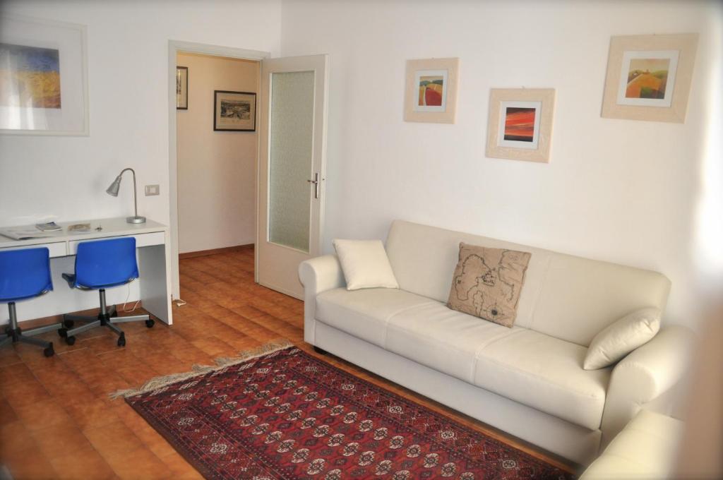 a living room with a white couch and a kitchen at Apartment Parmense in Parma