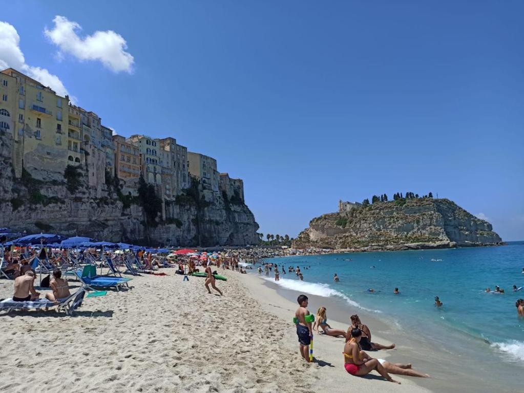 a group of people on a beach near the ocean at Le Roccette Club in Tropea