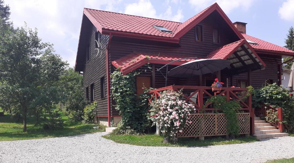 a house with a red roof and a porch at Leśne Berdo Przysłup in Cisna