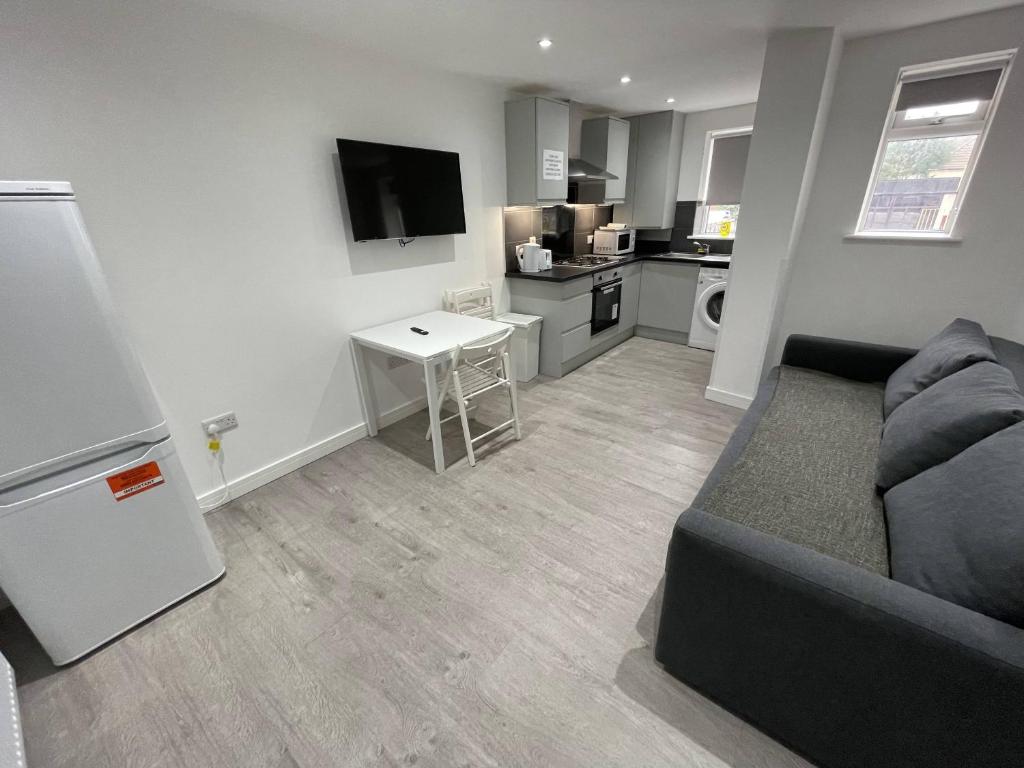 a living room with a couch and a kitchen at London Dagenham Apartments in Dagenham