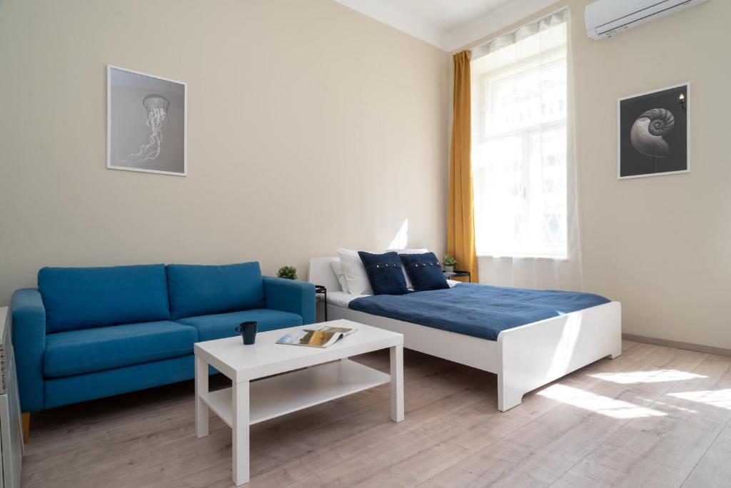 a living room with a blue couch and a table at Blue Ribbon Apartment in Budapest