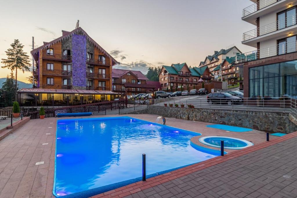 a large blue swimming pool in the middle of a city at Villa Elena SPA & Resort in Bukovel