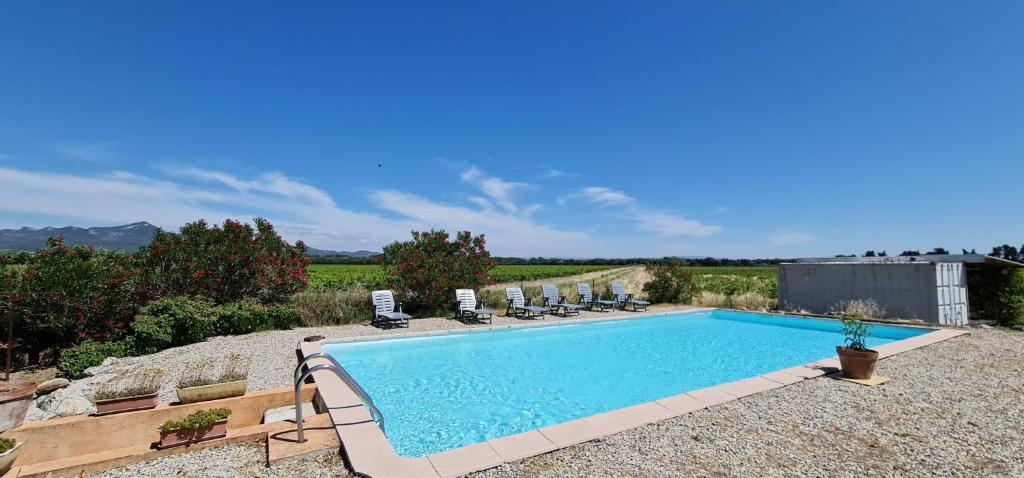 une piscine dans une cour avec des chaises longues dans l'établissement Studio 2 Personnes avec piscine, à Jonquières