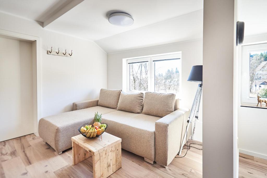 a living room with a couch and a bowl of fruit on a table at Smart Resorts Haus Saphir Ferienwohnung 507 in Winterberg