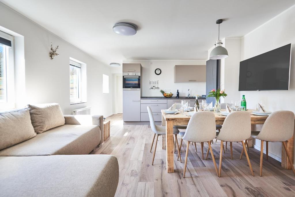 a living room with a couch and a table and chairs at Smart Resorts Haus Saphir Ferienwohnung 504 in Winterberg