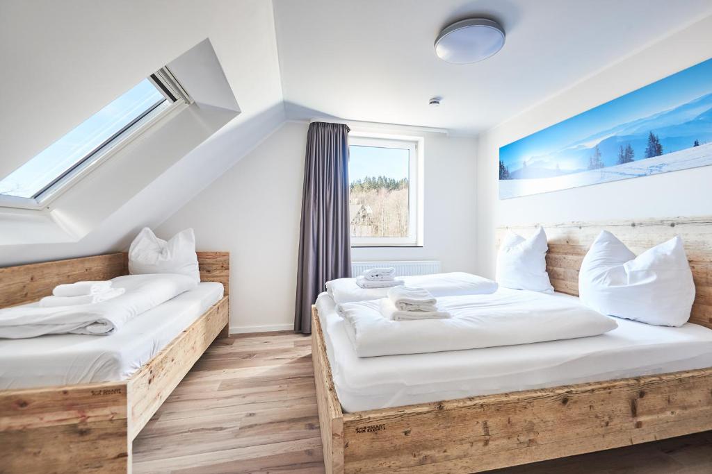 2 camas en una habitación con paredes blancas y ventana en Smart Resorts Haus Saphir Ferienwohnung 511 en Winterberg