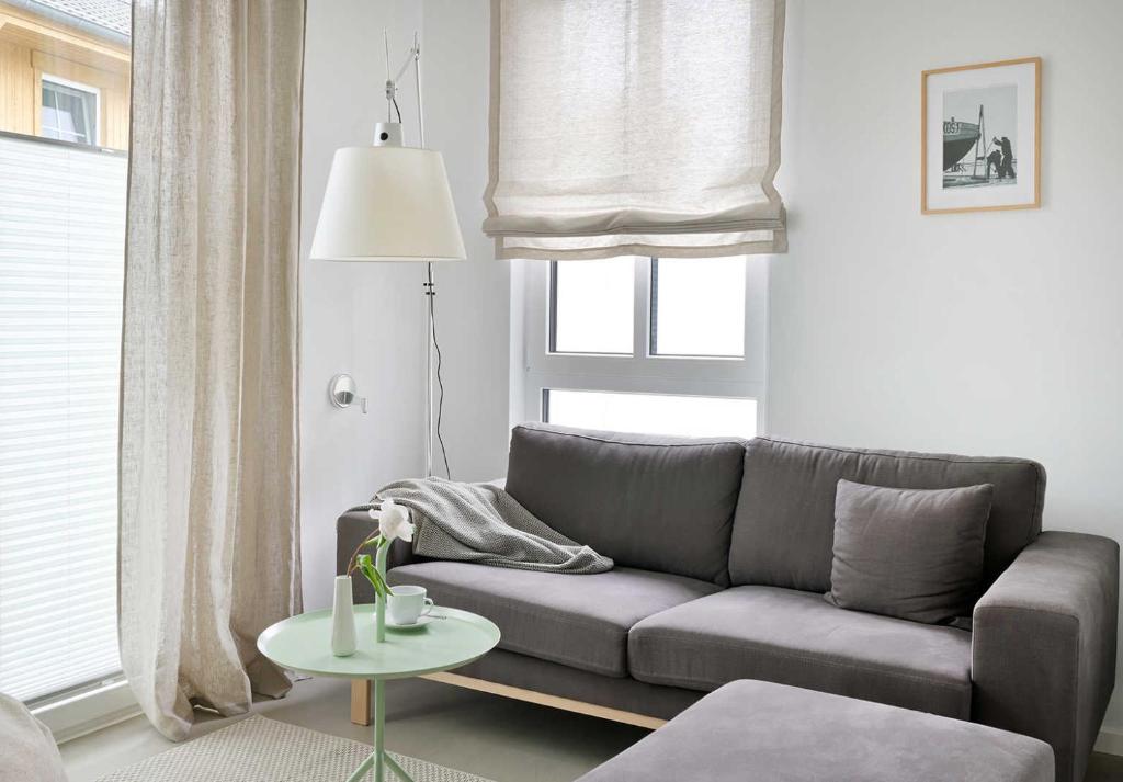 ein Wohnzimmer mit einer Couch und einem Tisch in der Unterkunft KOSI am Meer ACHT in Ostseebad Koserow
