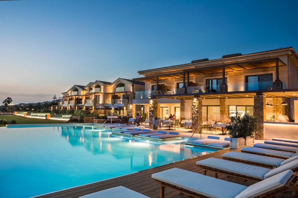 a hotel with a swimming pool with lounge chairs at Electra Kefalonia Hotel & Spa in Svoronata