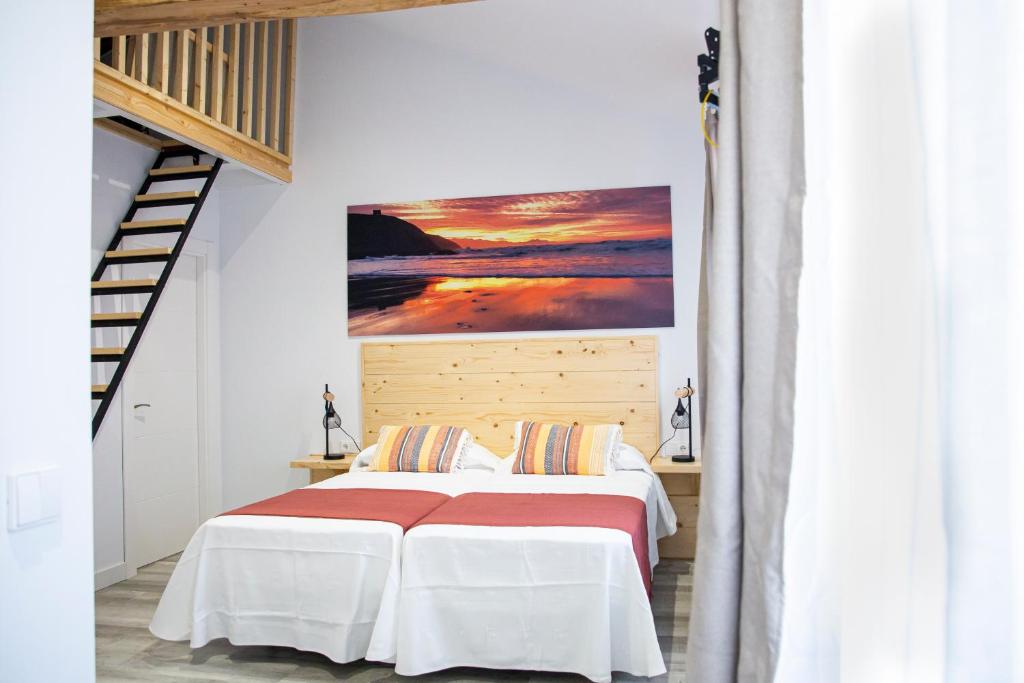 a bedroom with a bed with a painting on the wall at Hotel La Caracola Suances in Suances