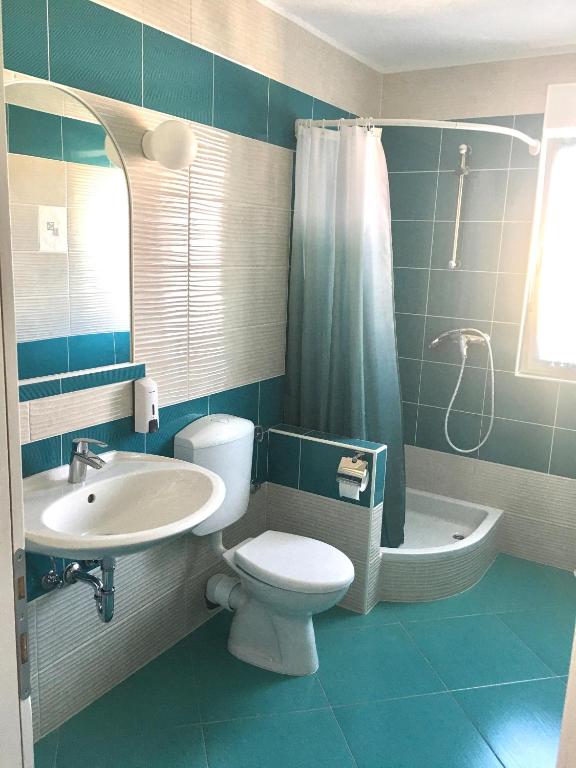 a bathroom with a toilet and a sink and a shower at Apartments MiaMaja in Novalja