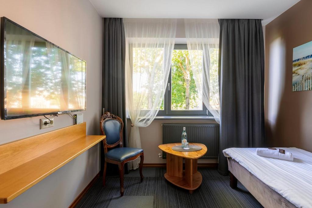 een hotelkamer met een bed, een tafel en een raam bij Comfort Hotel Kuldiga in Kuldīga