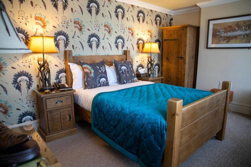 a bedroom with a bed with a blue bedspread at Smith And Western in Royal Tunbridge Wells
