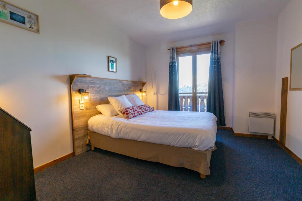 a bedroom with a large bed with a window at L'Escale (accès en télécabine) in Châtel