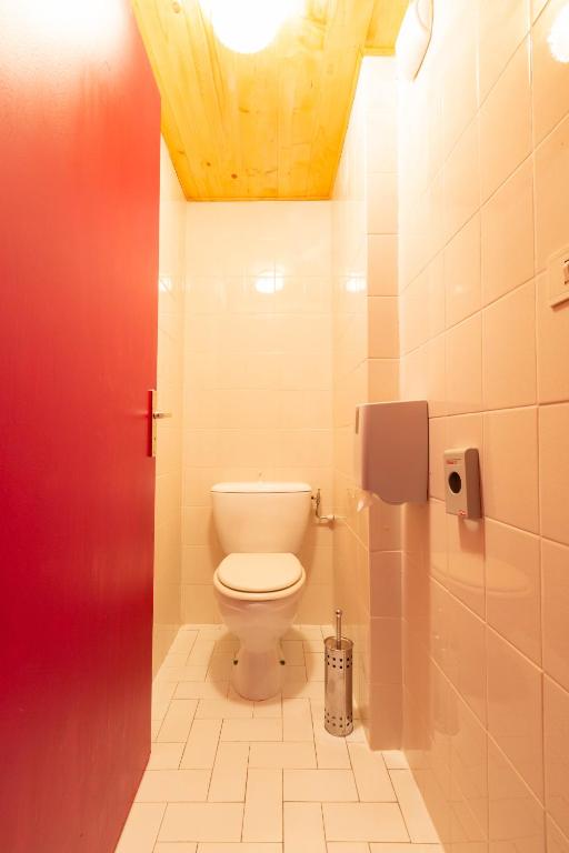 a bathroom with a white toilet in a stall at L'Escale (accès en télécabine) in Châtel