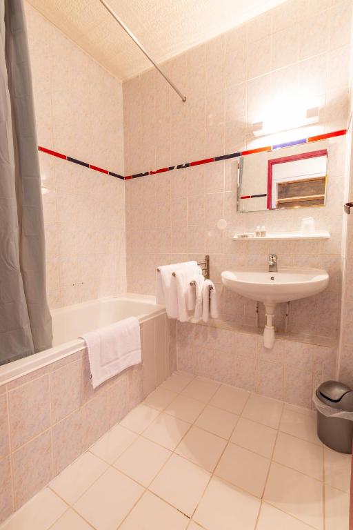 a bathroom with a sink and a tub and a toilet at L'Escale (accès en télécabine) in Châtel