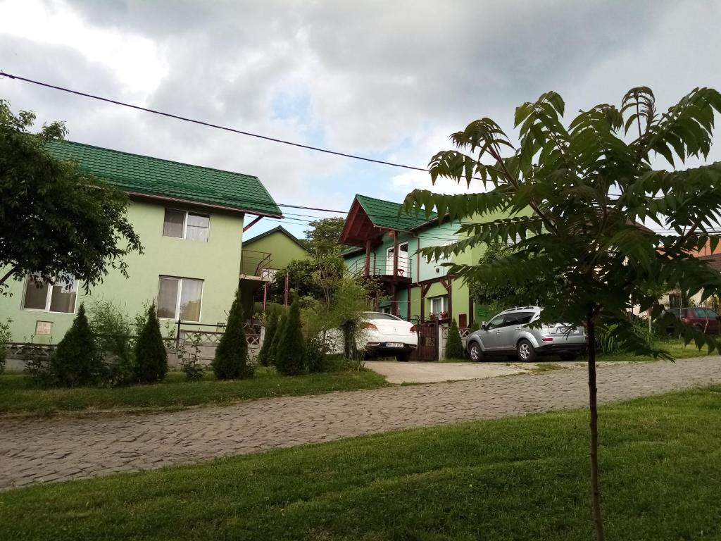 una fila de casas con un coche aparcado en una entrada en Pension Verde, en Baia-Sprie