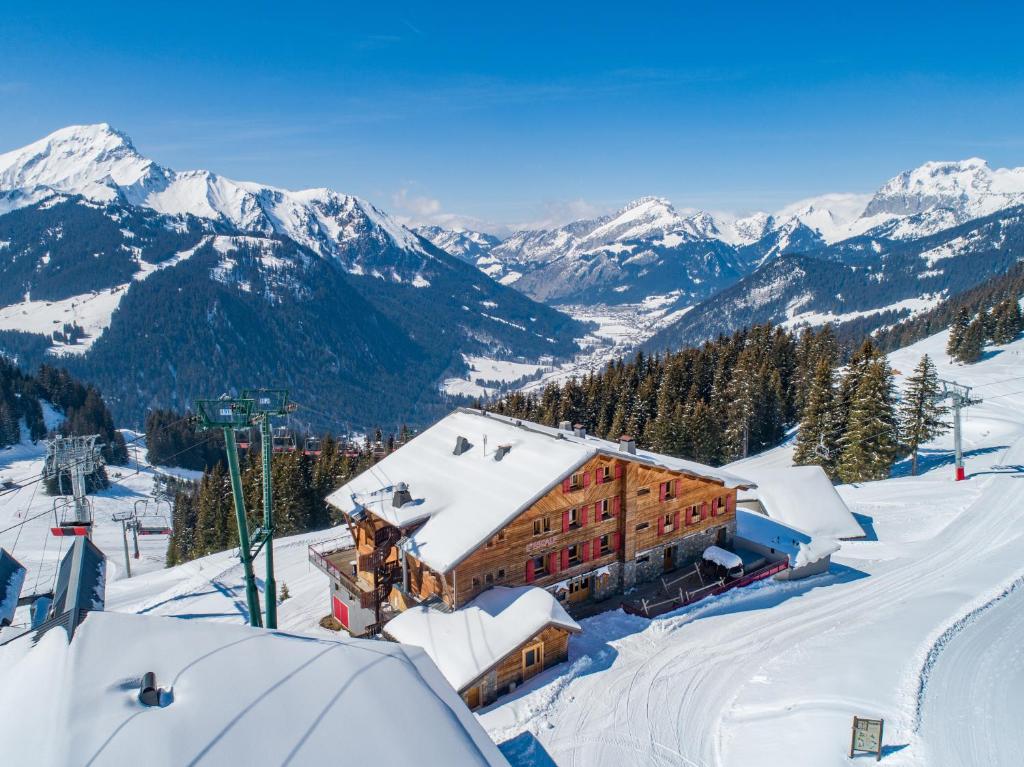 un edificio en una pista de esquí con montañas cubiertas de nieve en L'Escale (accès en télécabine), en Châtel