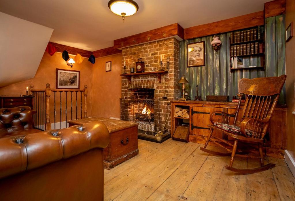 a living room with a couch and a fireplace at Fagins Den Themed Holiday Cottage Broadstairs in Broadstairs
