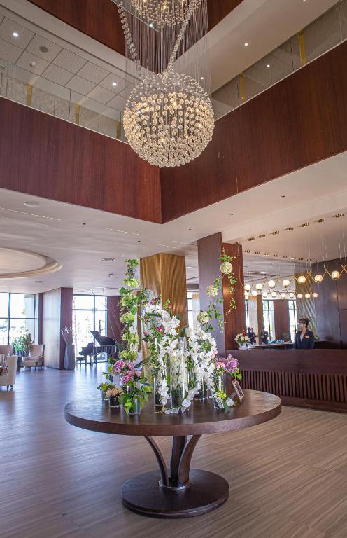 a lobby with a table with vases of flowers on it at Waves Aqua Resort in Kenitra