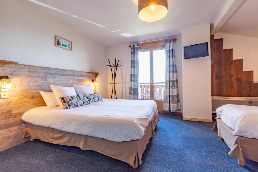 a hotel room with two beds in it at L'Escale (accès en télécabine) in Châtel