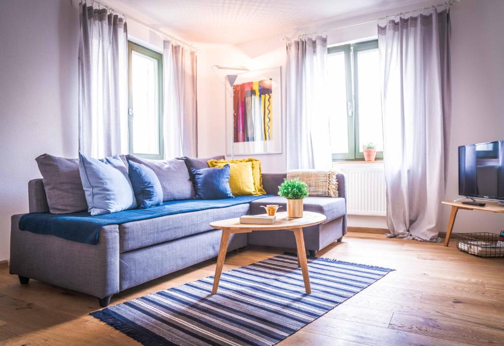 uma sala de estar com um sofá azul e uma mesa em Besighomes - Apartment Blues em Besigheim