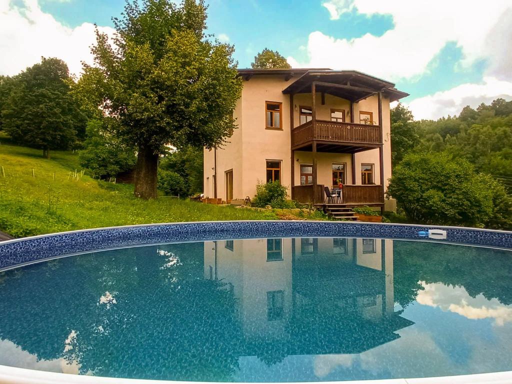 a large swimming pool in front of a house at OVCA Apartament in Piechowice