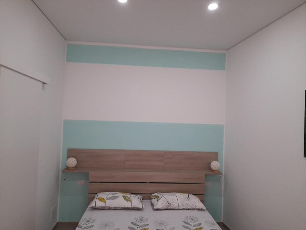 sypialnia z łóżkiem z drewnianym zagłówkiem w obiekcie Ortigia spartan house 3 w Syrakuzach