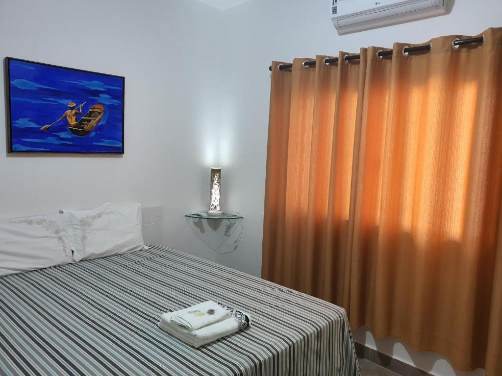 クイアバにあるSuite 03 - Independente, privativa e aconcheganteのベッドルーム1室(ベッド1台、シャワーカーテン付)